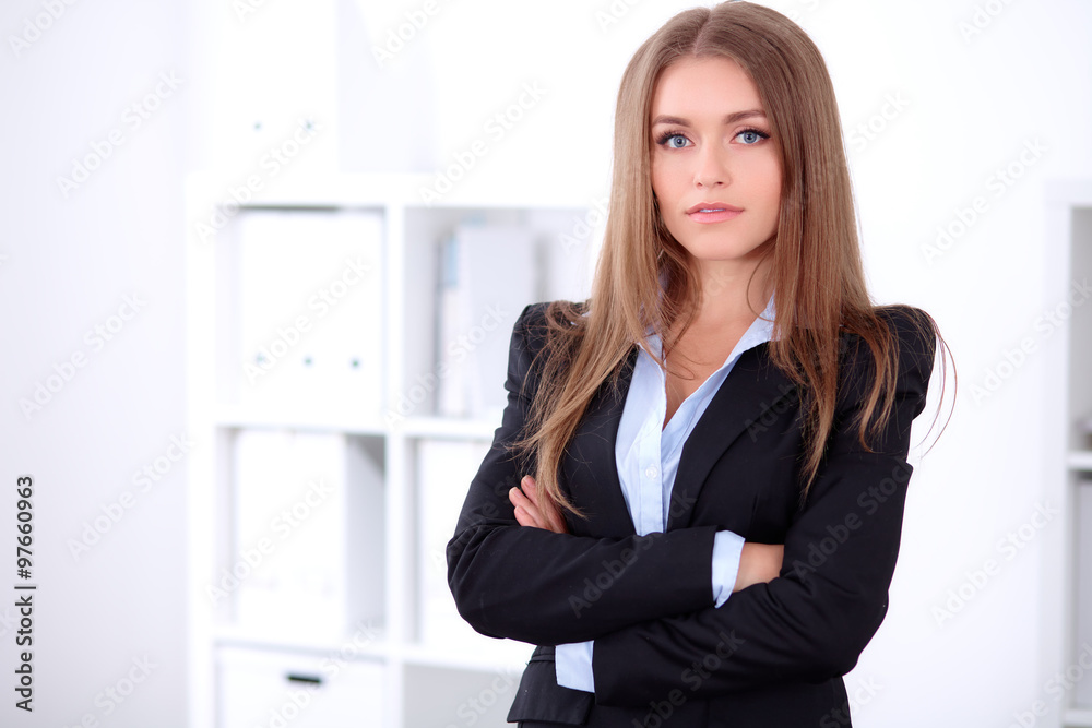 Pretty brunette business lady in the office in a black jacket, crossed arms Pretty brunette business lady in the office in a black jacket, crossed arms