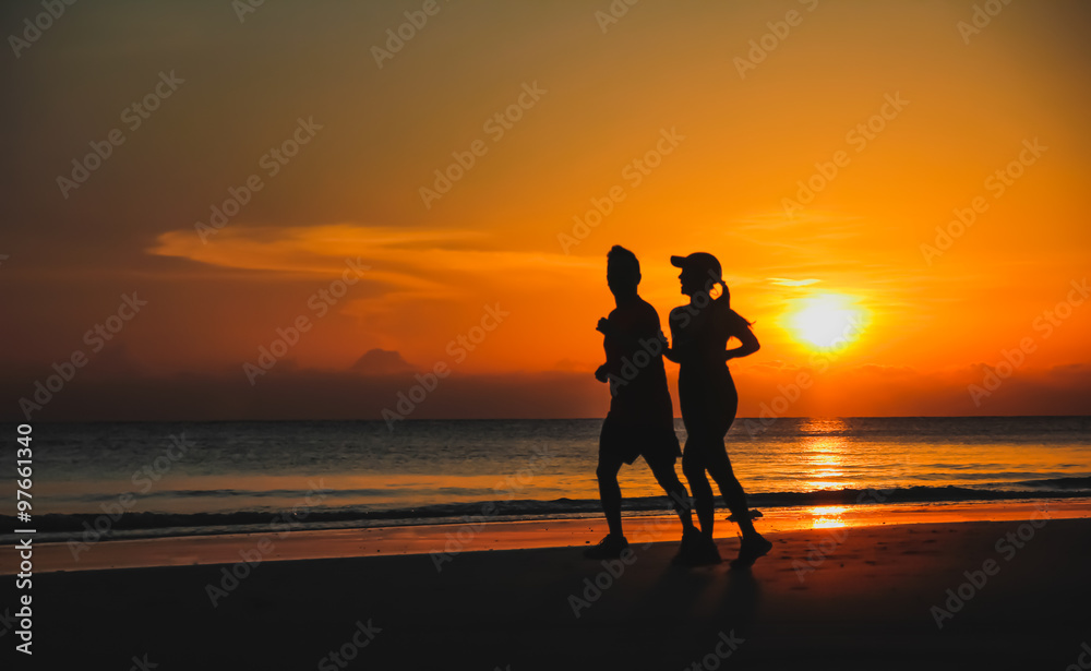 Fototapeta premium Young couple: man and woman run together on a sunset on lake coa