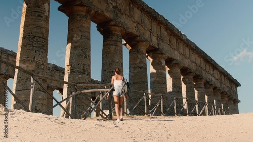 Tourist girl visiting Segesta Greek temple in Sicily, Italy

