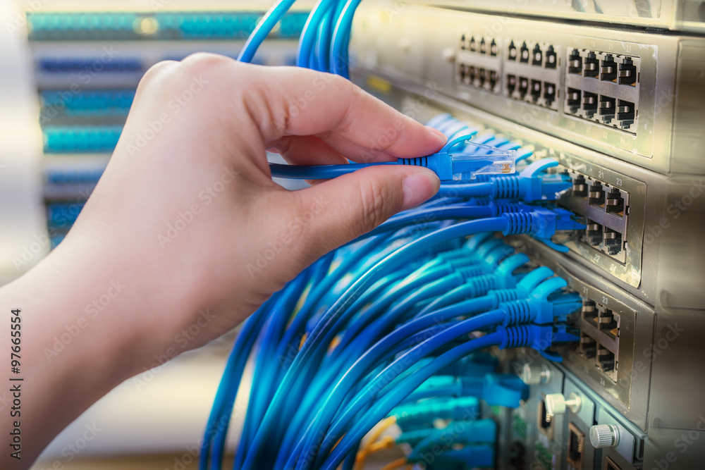 hand with network cables connected to servers in a datacenter hand with network cables connected to servers in a datacenter