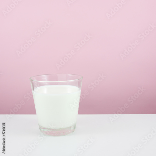 The glass of fresh milk on the white table.