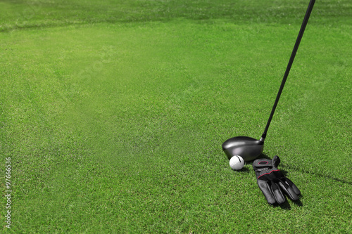 Wallpaper Mural Golf clubs with ball and black glove on a green grass, close up Torontodigital.ca