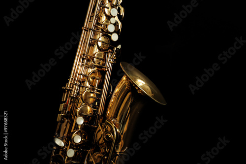 Beautiful golden saxophone on black background, close up photo