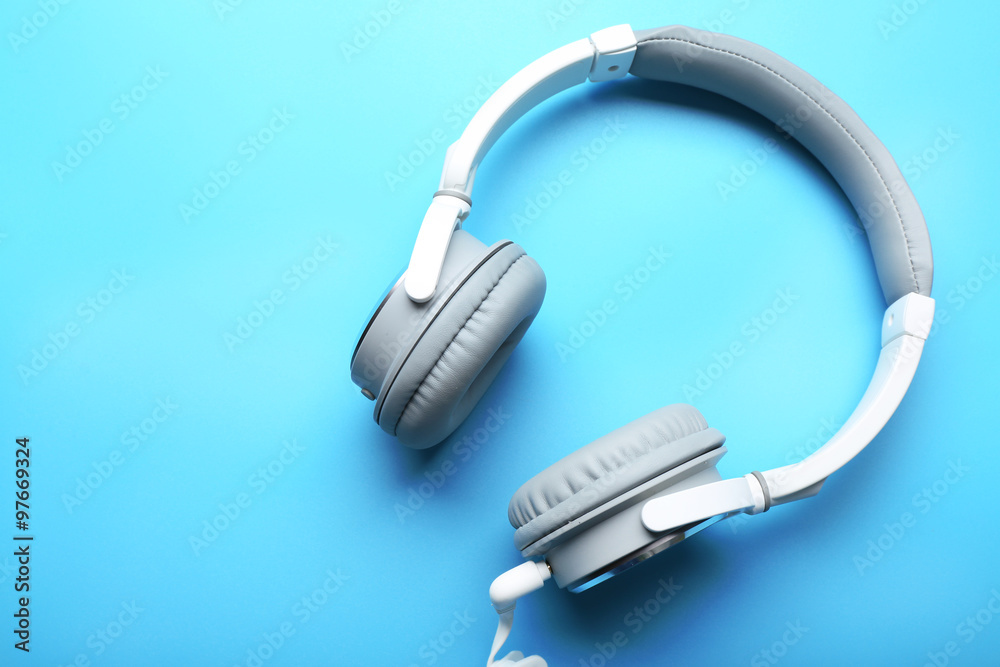 White and grey headphones on blue background White and grey headphones on blue background