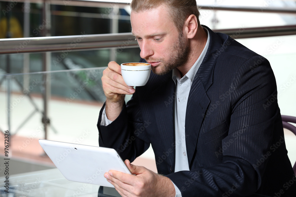 Young attractive businessman having lunch and working in a cafe Young attractive businessman having lunch and working in a cafe