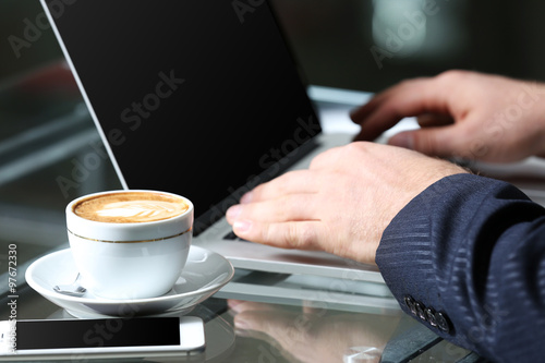 Businessman having lunch and working in a cafe, close-up
