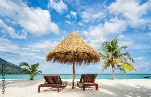 Beach chairs, umbrella and palms on the beach. Thailand. Koh Lipe island.
