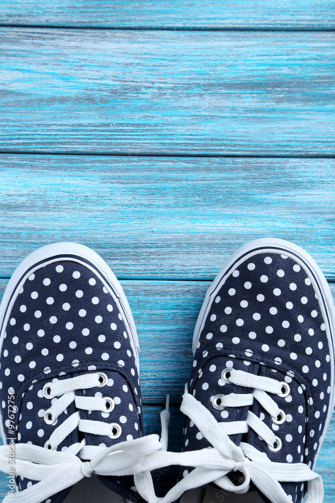 Naklejka premium Female gumshoes on blue wooden background