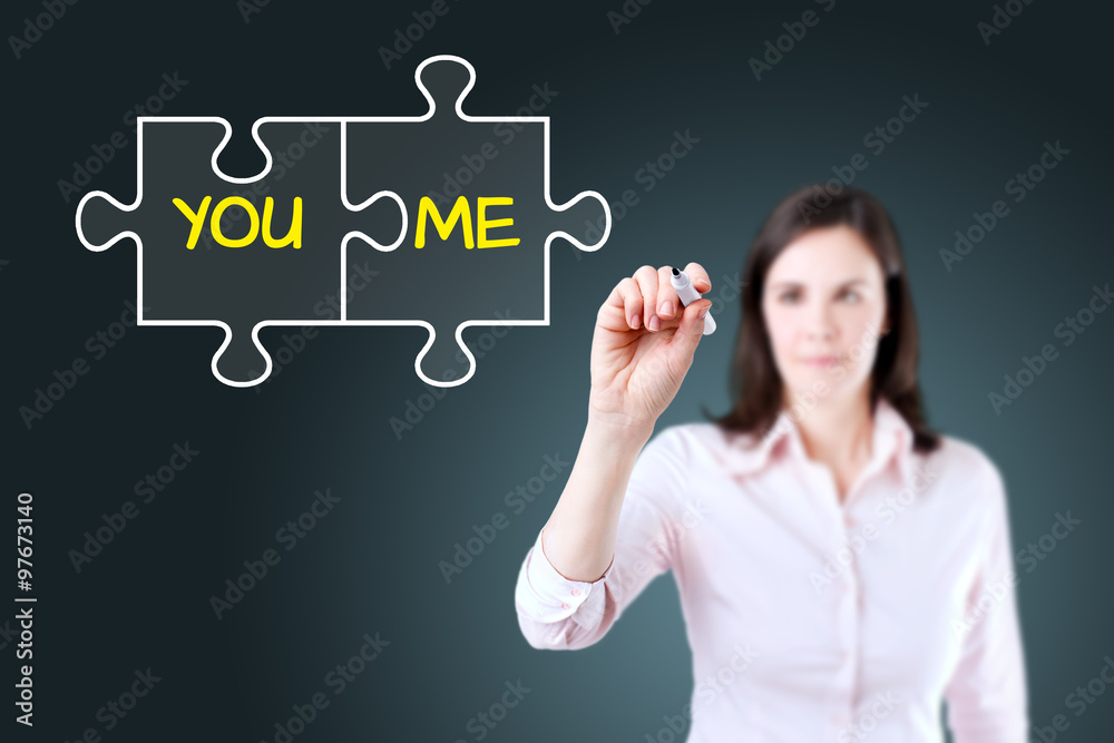 Businesswoman drawing a You and Me puzzle love concept on the virtual screen. Blue background.