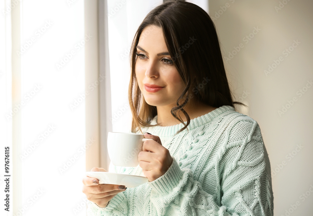 Woman standing near window in the room, close up Woman standing near window in the room, close up