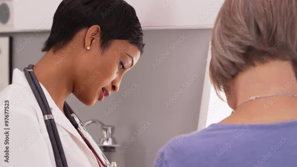 Young female radiologist with senior female patient looking x-ray Young female radiologist with senior female patient looking x-ray