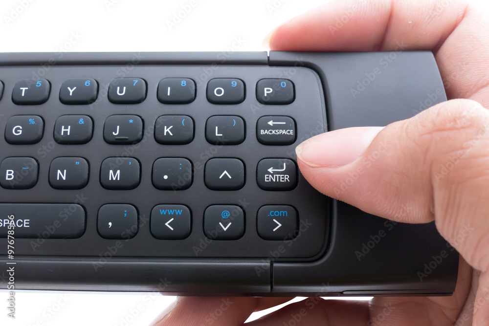 Hand holding mini wirless keyboard and push enter key button ove