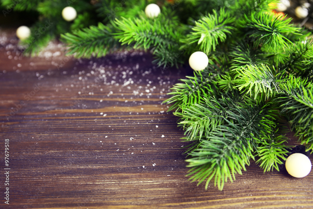 Christmas fir tree branches with lights on wooden table Christmas fir tree branches with lights on wooden table
