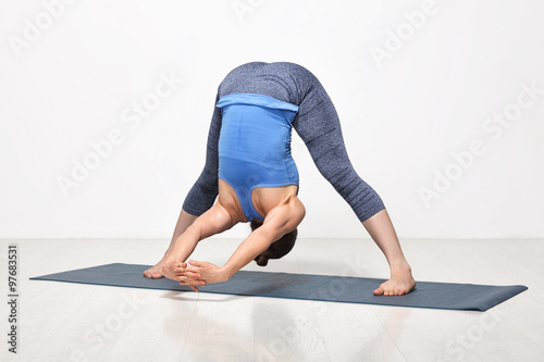 Woman practices Ashtanga Vinyasa yoga asana