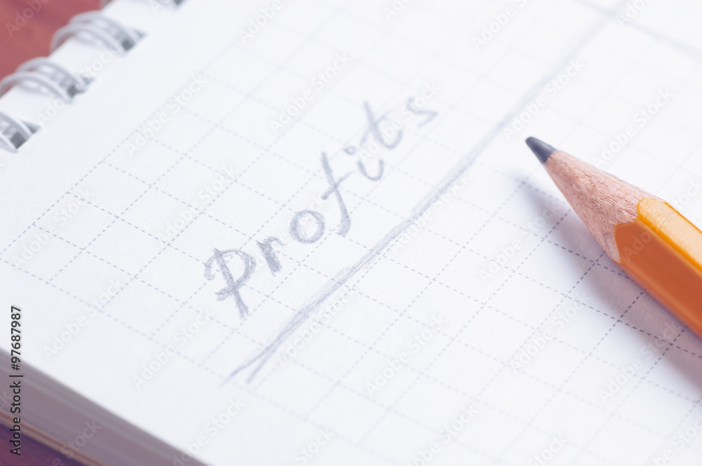 Notepad with handwritten word Profits by grey pencil lying over paper sheet cold filtered shallow depth of field Notepad with handwritten word Profits by grey pencil lying over paper sheet cold filtered shallow depth of field