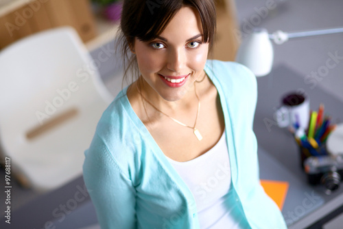 Portrait of young woman sitting at desk 