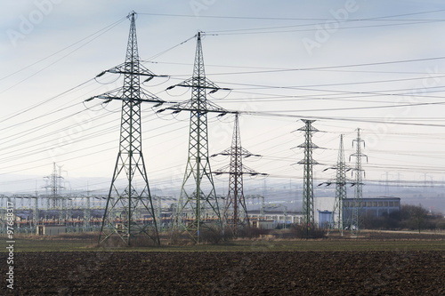 Distribution power station with electricity pylons and dramatic cloudy sky background