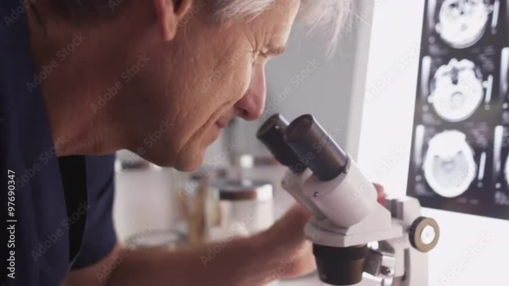 Intelligent male radiologist analyzing with microscope Intelligent male radiologist analyzing with microscope