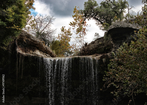 Rocky waterfall and trees at Hamilton Pool park in Austin, Texas.