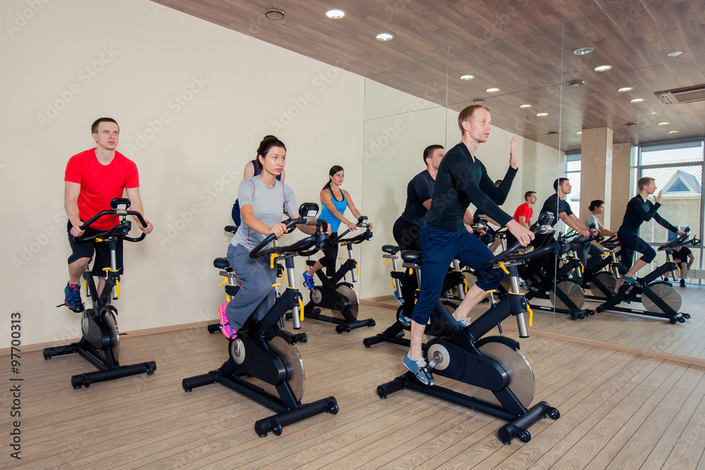 Obraz premium Group of gym people on machines, cycling In Class