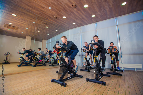 Group of gym people on machines, cycling In Class © satyrenko