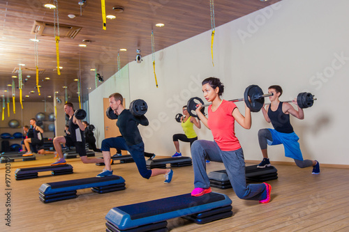 Sport, fitness, lifestyle and people concept - group flexing muscles with barbells in gym