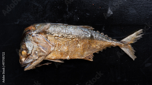 fried Short-bodied mackerel on black wooden plate photo