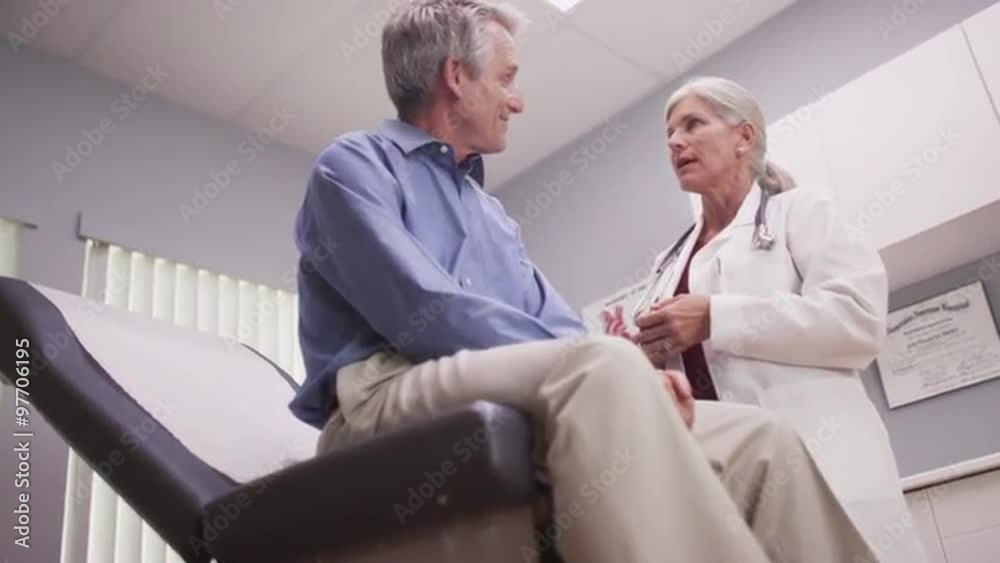 Attractive senior female doctor checking male patient's vitals Attractive senior female doctor checking male patient's vitals