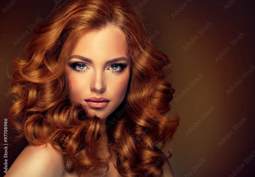 Poster Girl model with long red wavy hair. Big curls on the red head . Hairstyle  permanent waving 