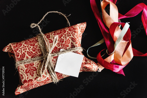 beautiful gorgeous present in design paper with ribbons and gree