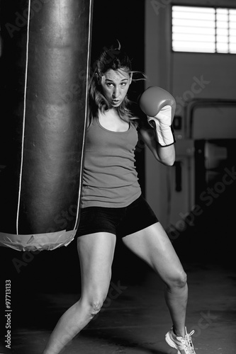 Female boxer kicking punching bag