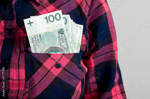 Kobieta wyciąga polskie pieniądze z kieszeni
