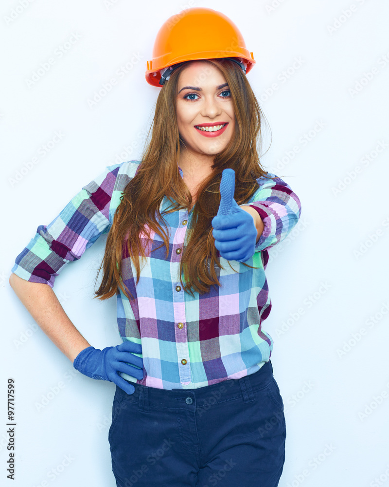 Woman in builder style portrait against white wal show thumb up Woman in builder style portrait against white wal show thumb up
