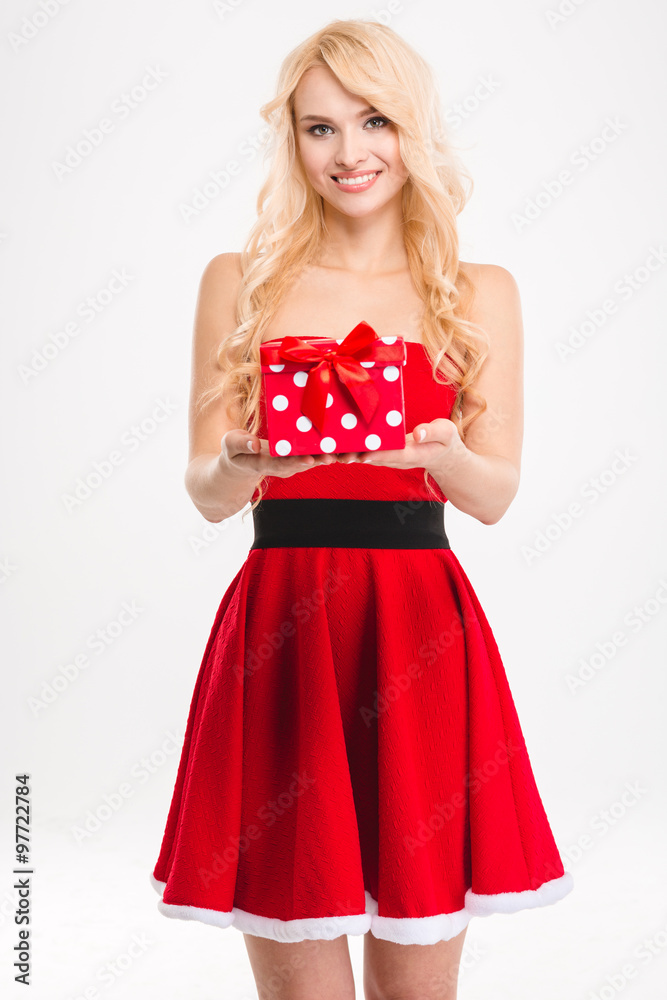 Cheerful blonde girl in red santa claus costume holding present Cheerful blonde girl in red santa claus costume holding present