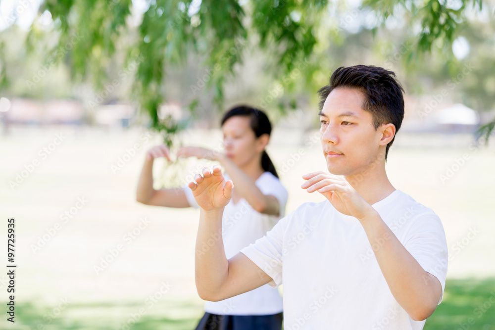 People practicing thai chi in park People practicing thai chi in park