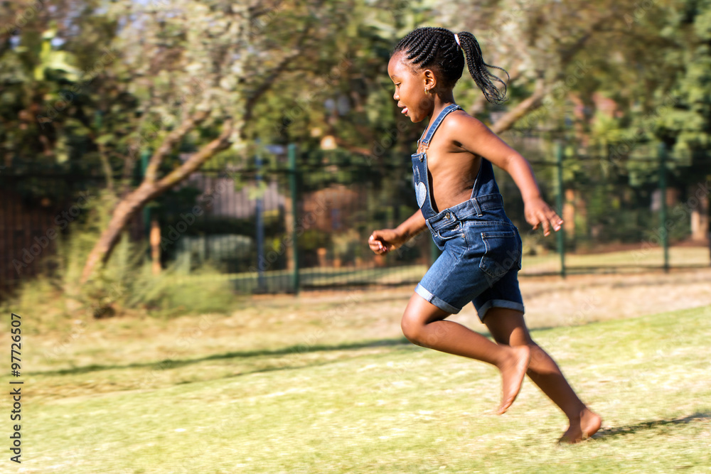 Side view of african kid running in park. Side view of african kid running in park.