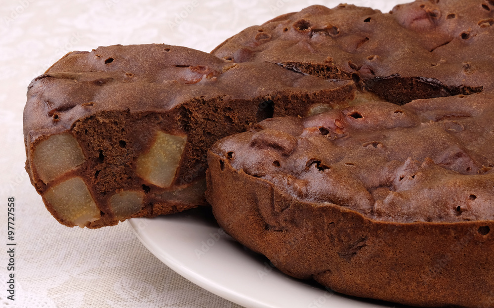 Homemade chocolate cake with pieces of pears on a white plate. Homemade chocolate cake with pieces of pears on a white plate.