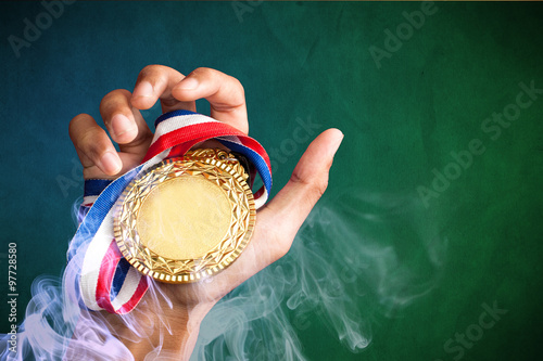 hand holding up a gold trophy cup as a winner in a competition