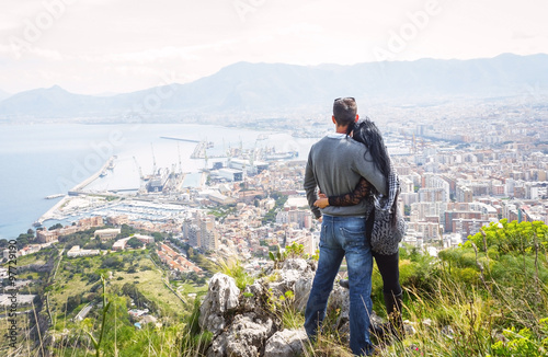 Couple holding each other, enjoying view above city of Palermo on top of Mount Pellegrino, Palermo, Sicily, Italy photo