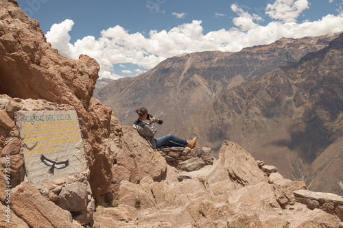Young woman photographing condors in Colca, Arequipa, Peru photo