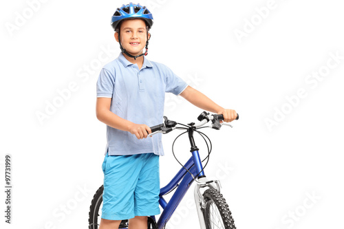 Little boy posing next to his bicycle