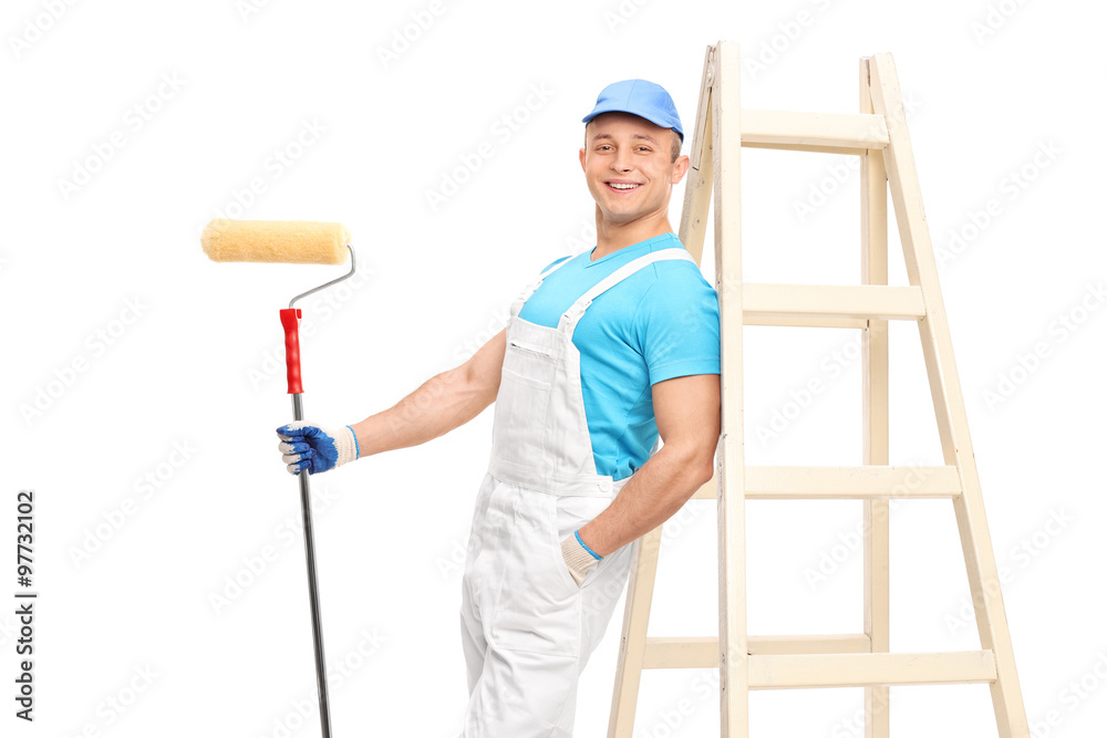 Young male decorator holding a paint roller Young male decorator holding a paint roller