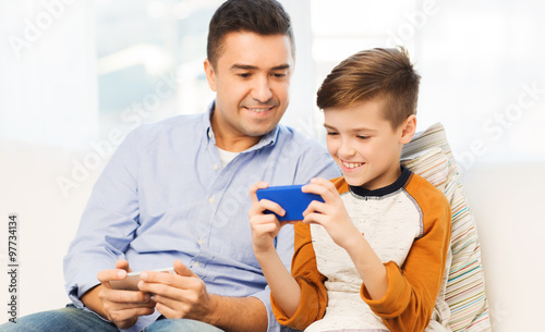 happy father and son with smartphone at home