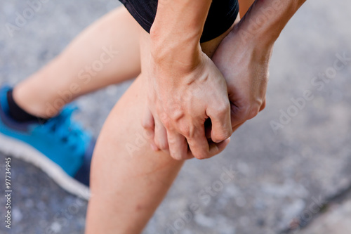Runner touching painful knee. Athlete runner training accident. Sport running knee sprain.