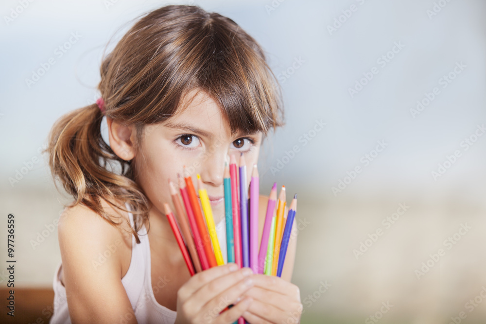 Little happy hiding her face with colored pencils Little happy hiding her face with colored pencils