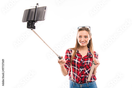 Long-haired girl with selfie stick taking photo
