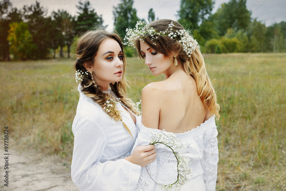 Fototapeta premium Two women in white dresses