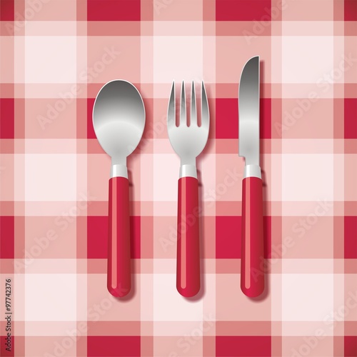 Cuchara, tenedor y cuchillo. Cubiertos sobre fondo de cuadros rojo