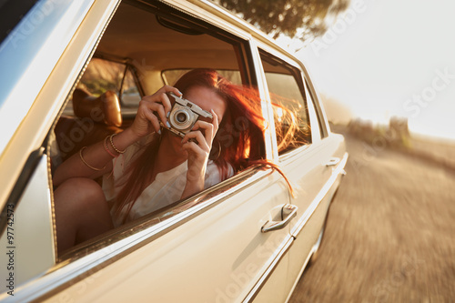 Female capturing a perfect road trip moment.