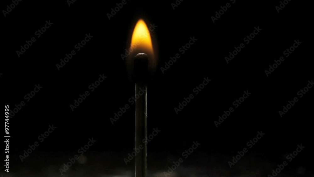 A match lights on a dark black background A match lights on a dark black background